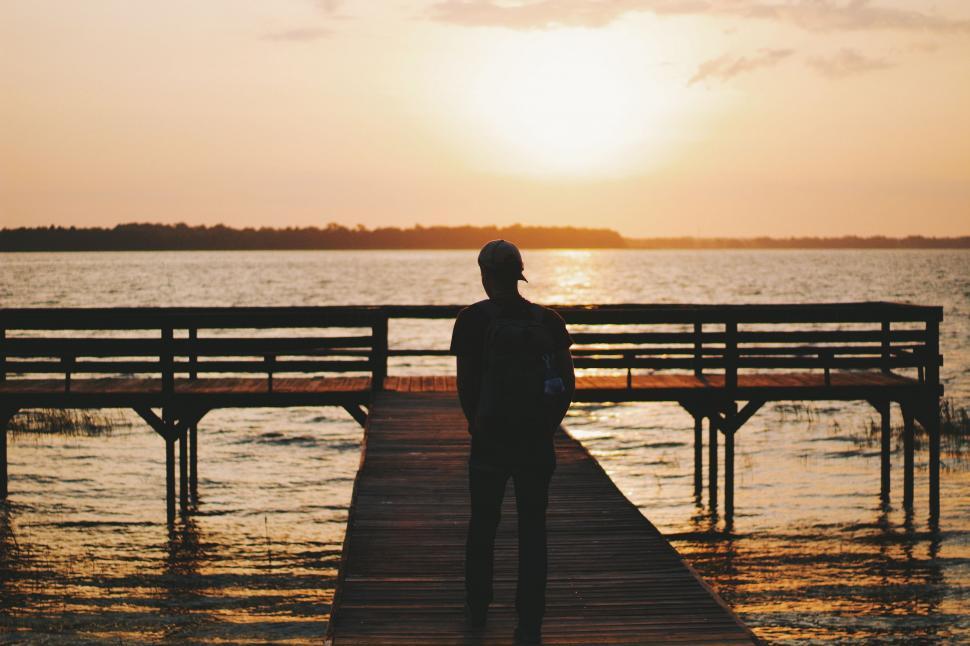 Free Image of Man Standing on Dock Watching Sunset 