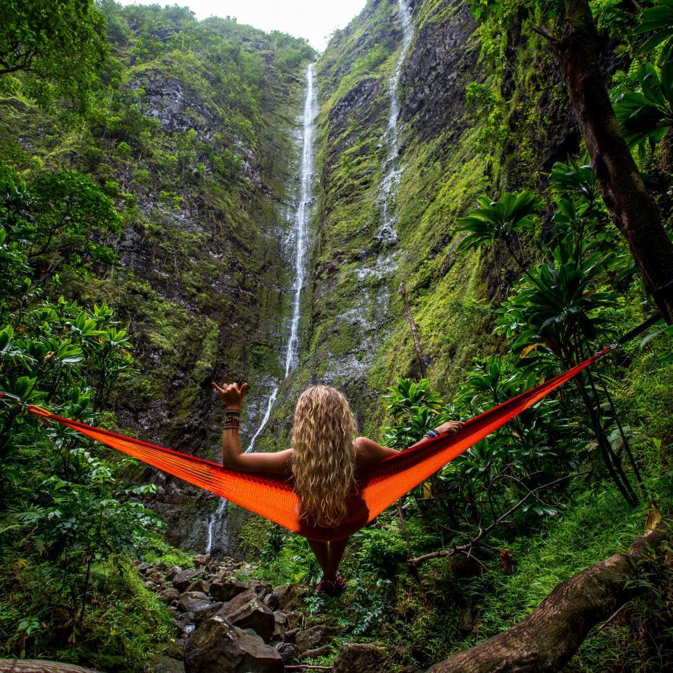 Free Image of Woman Relaxing in Red Hammock by Waterfall 