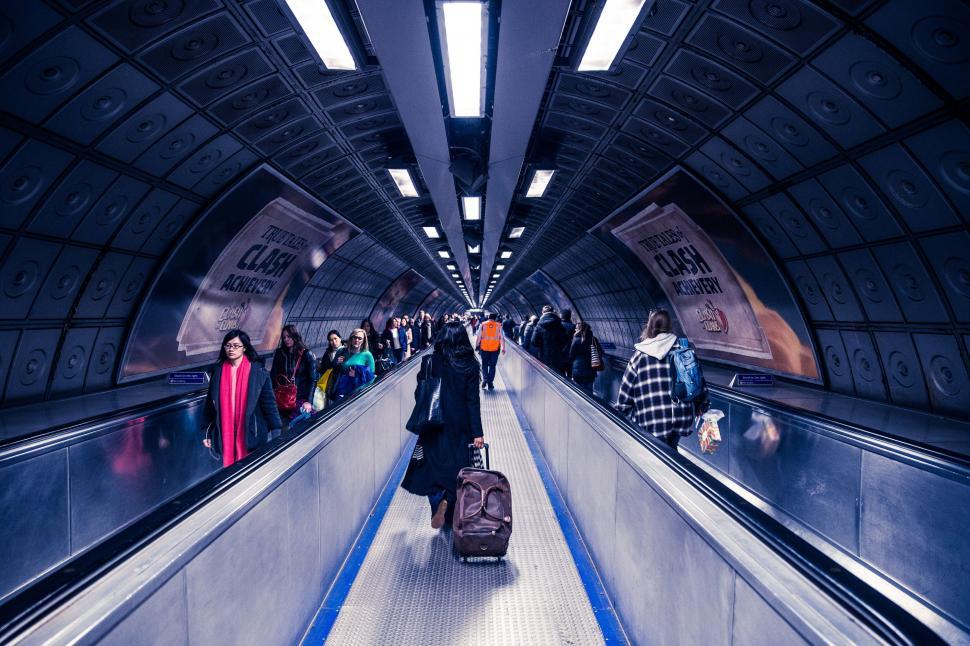 Free Image of Group of People Walking Down Escalator With Luggage 