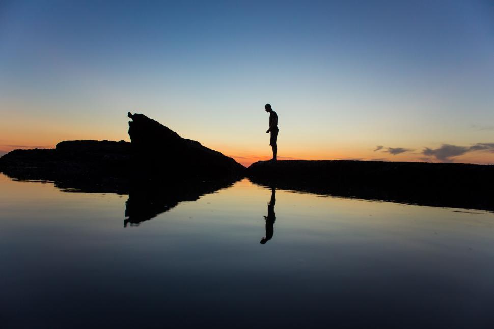 Free Image of Person Standing on Rock in Middle of Lake 