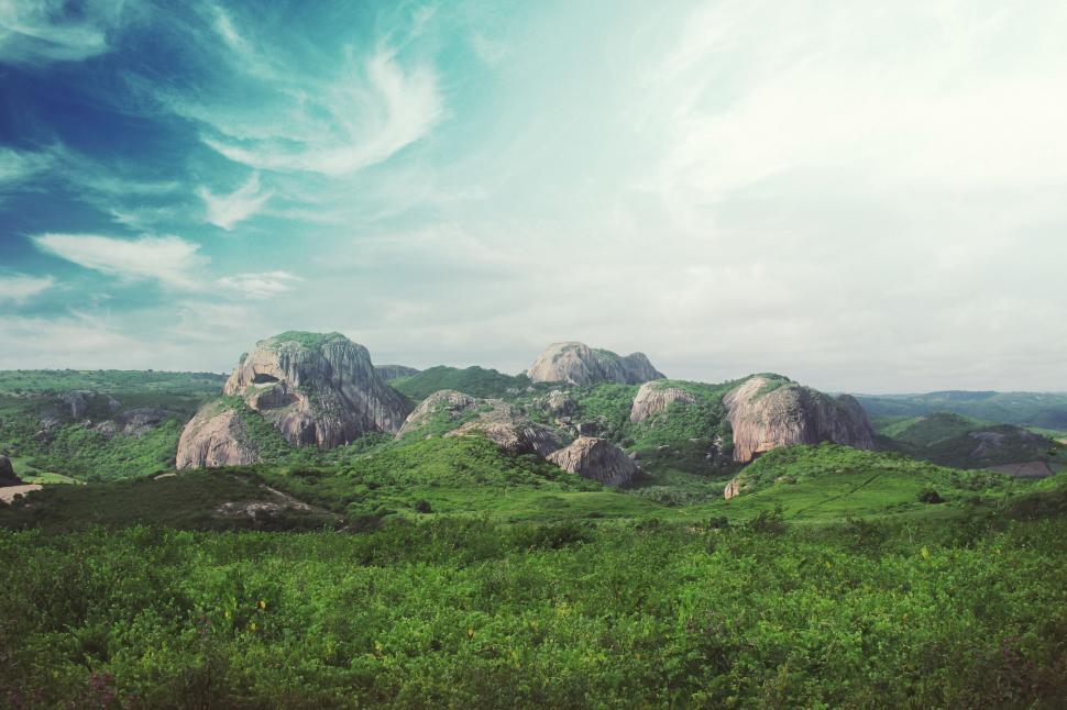 Free Image of Green Field With Rocks in Background 