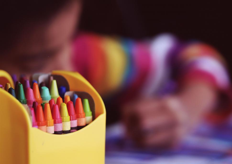 Free Image of Child Drawing With Colored Crayons in Pencil Holder 