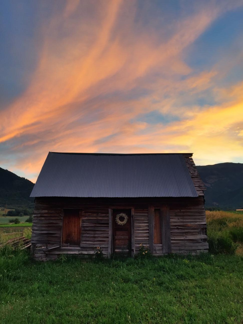 Free Image of Small Cabin in Field With Sunset 