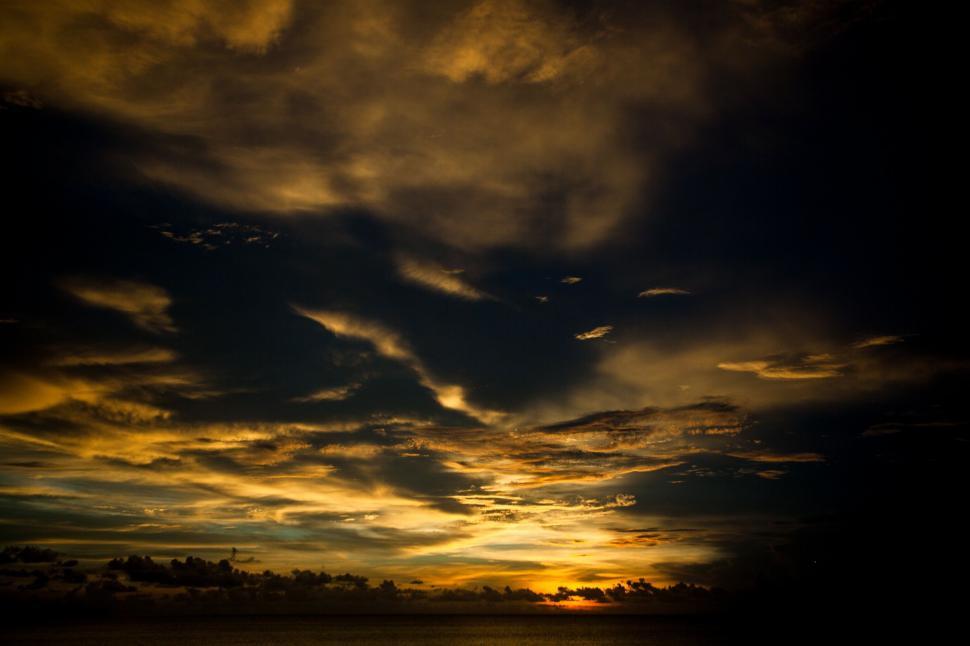 Free Image of Sun Setting Over Ocean With Clouds in Sky 