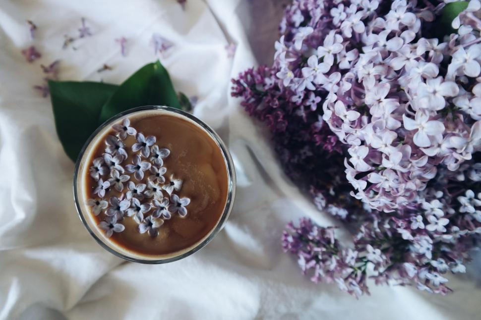 Free Image of Close Up of Coffee Cup With Flowers in Background 