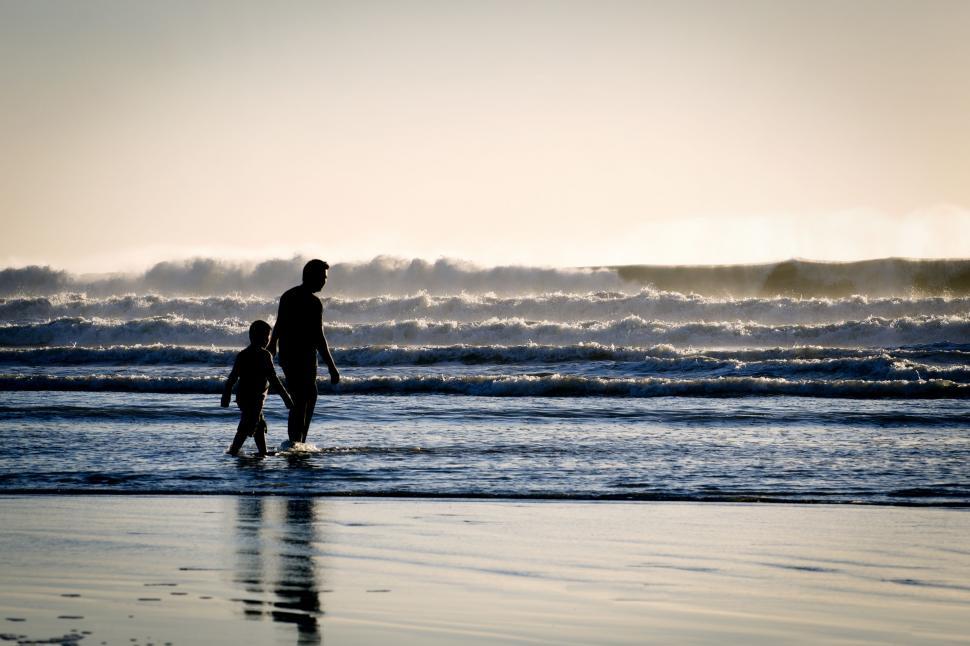 Free Image of Man and Child Walking on Beach 