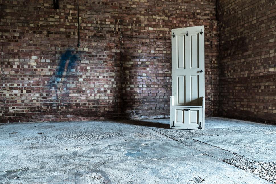 Free Image of Empty Room With Brick Walls and White Door 