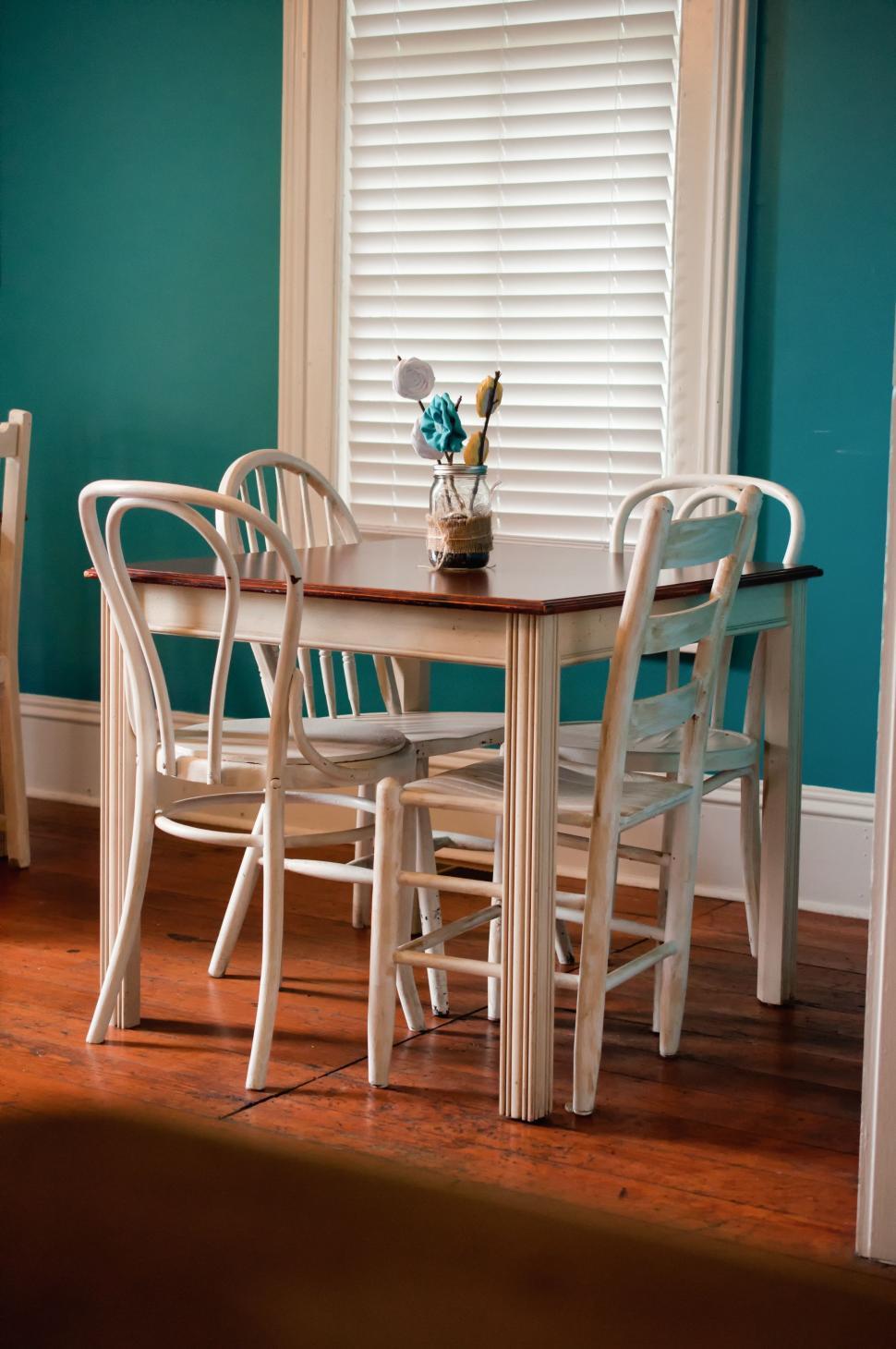 Free Image of Dining Room Table With Chairs and Vase of Flowers 