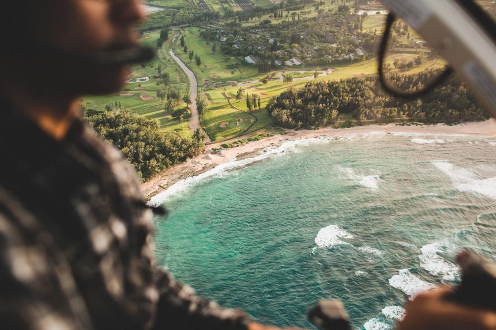 Free Image of Man Flying Helicopter Over Ocean 