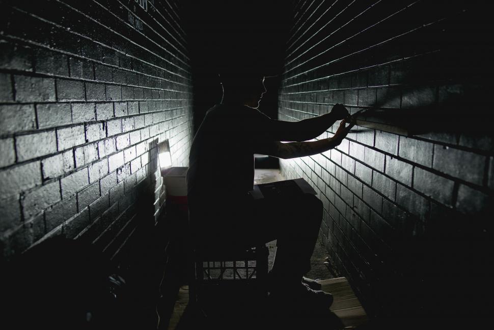 Free Image of Man Sitting on Chair in Dark Room 