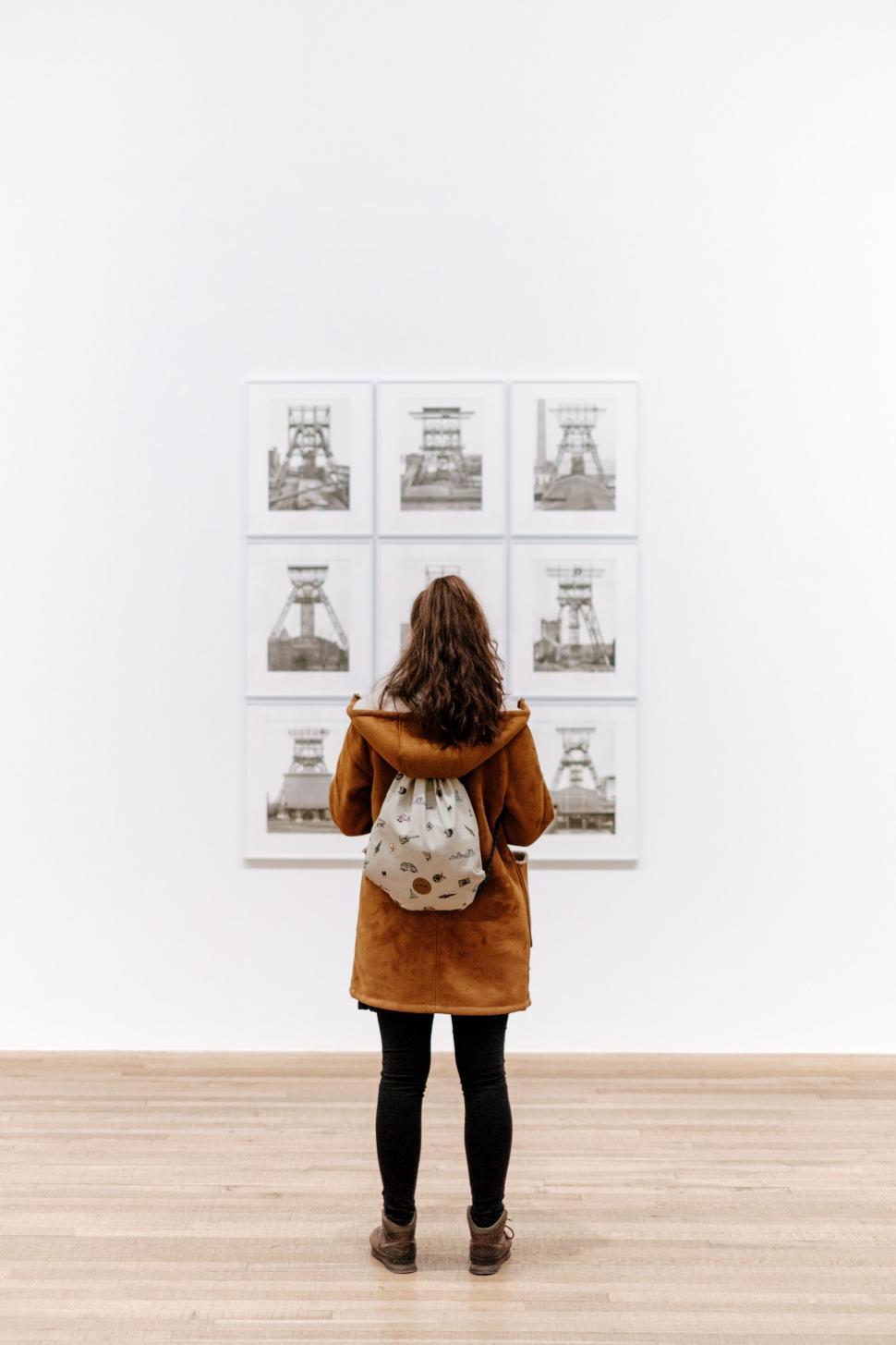 Free Image of Woman Standing in Front of Wall With Pictures 