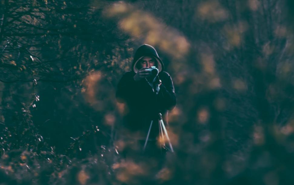 Free Image of Person Standing in Woods Holding Camera 