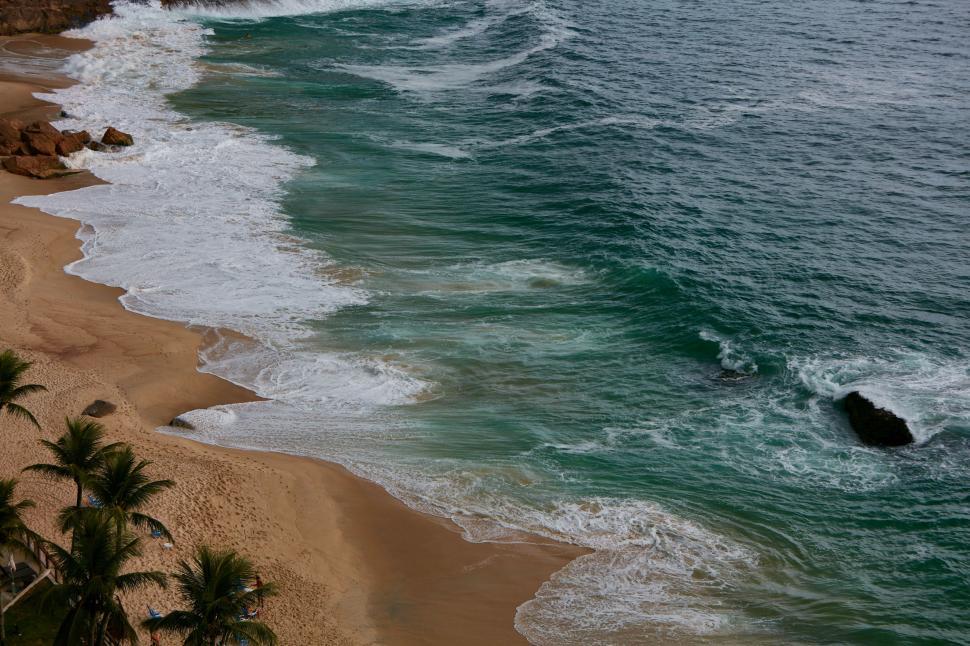 Free Image of A View of a Beach With Waves Coming in From the Ocean 