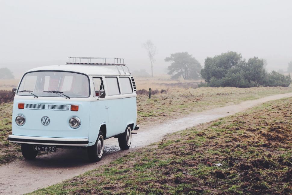 Free Image of VW Bus Driving Down a Dirt Road 