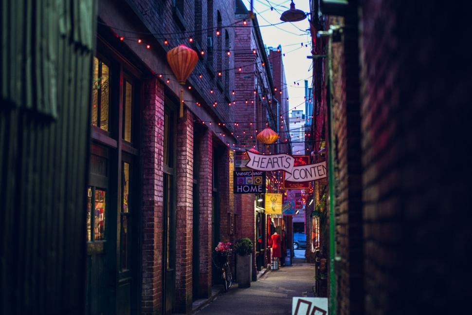 Free Image of Narrow City Street With Lights Hung From Buildings 