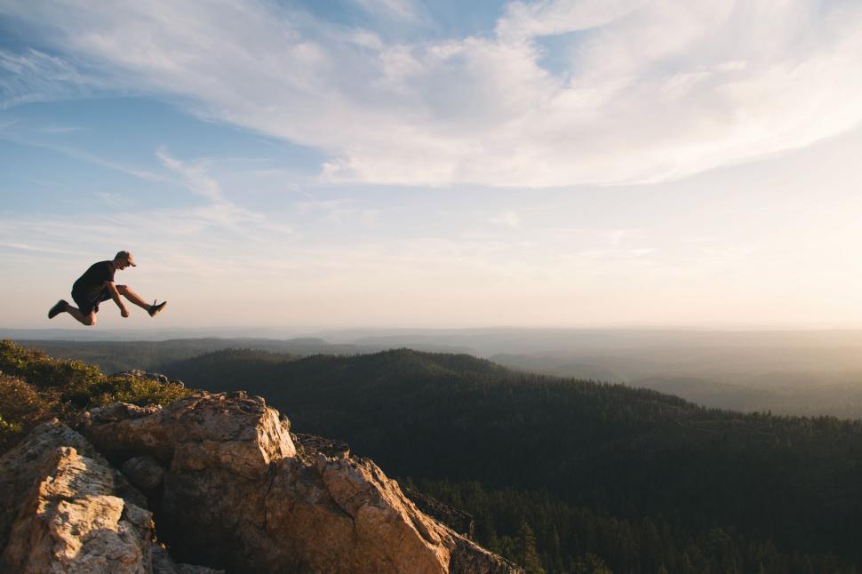 Free Image of Man Jumping Off Cliff Into the Air 