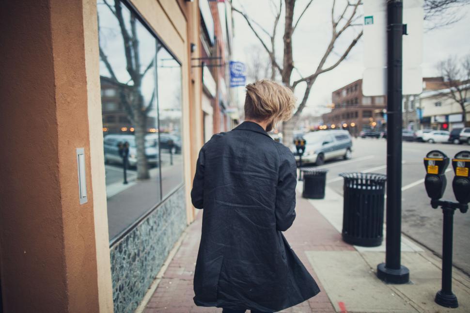 Free Image of Woman Walking Along Sidewalk by Parking Meter 