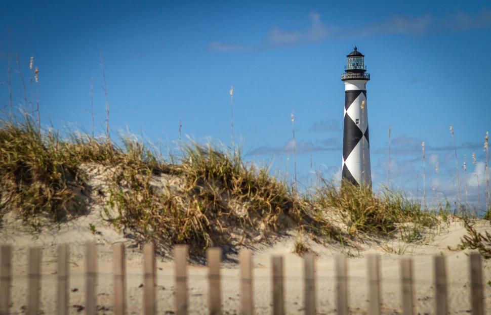 Free Image of Black and White Lighthouse on Sandy Beach 