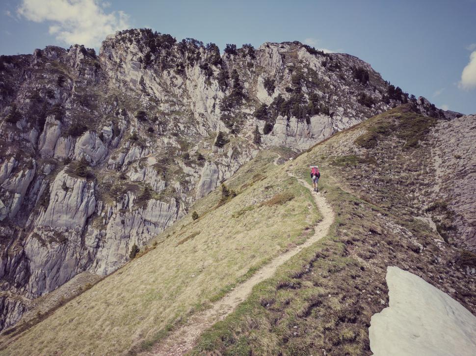 Free Image of Person Climbing Steep Hill With Mountain in Background 