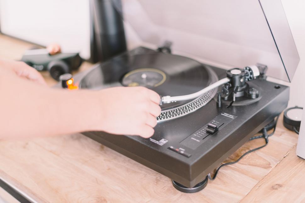 Free Image of Person Using a Record Player on Wooden Table 