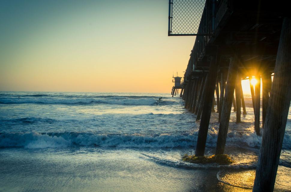 Free Image of The Sun Sets at the End of a Pier 