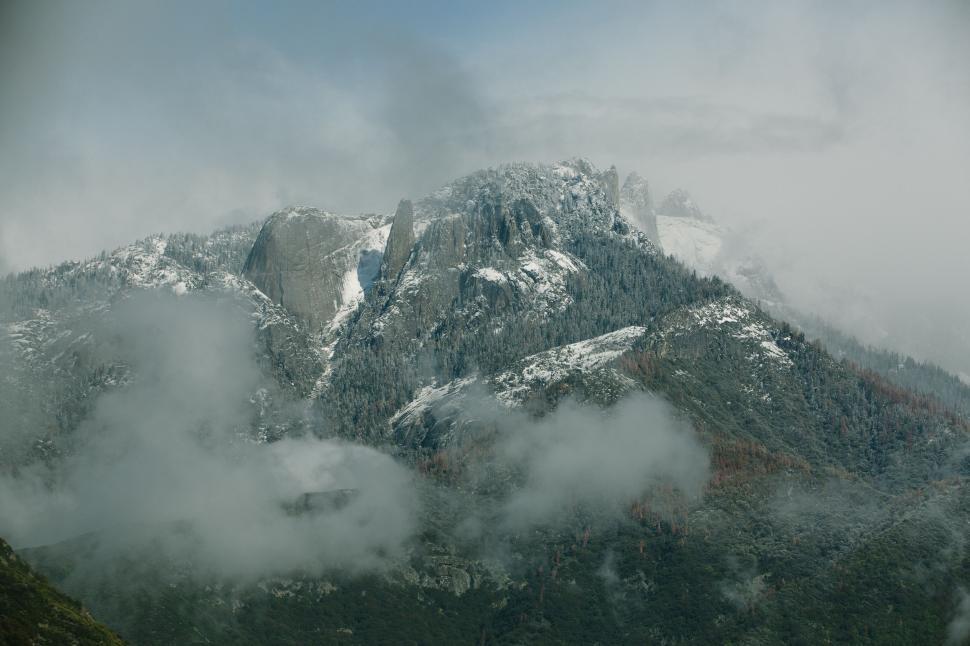 Free Image of Majestic Mountain Blanketed in Snow and Clouds 