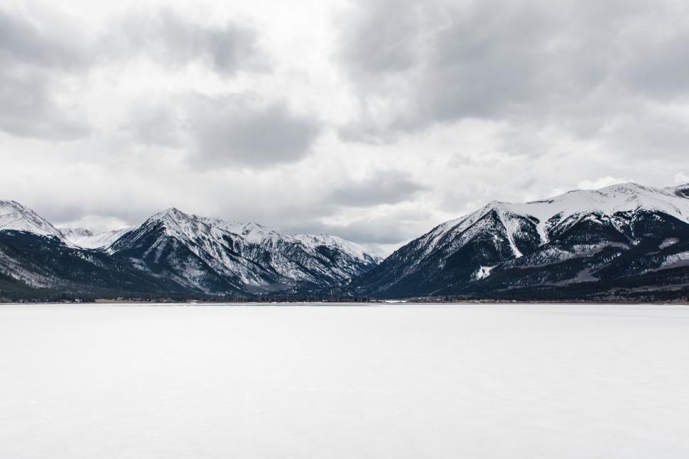 Free Image of Snow-Covered Mountains Surrounding Large Body of Water 