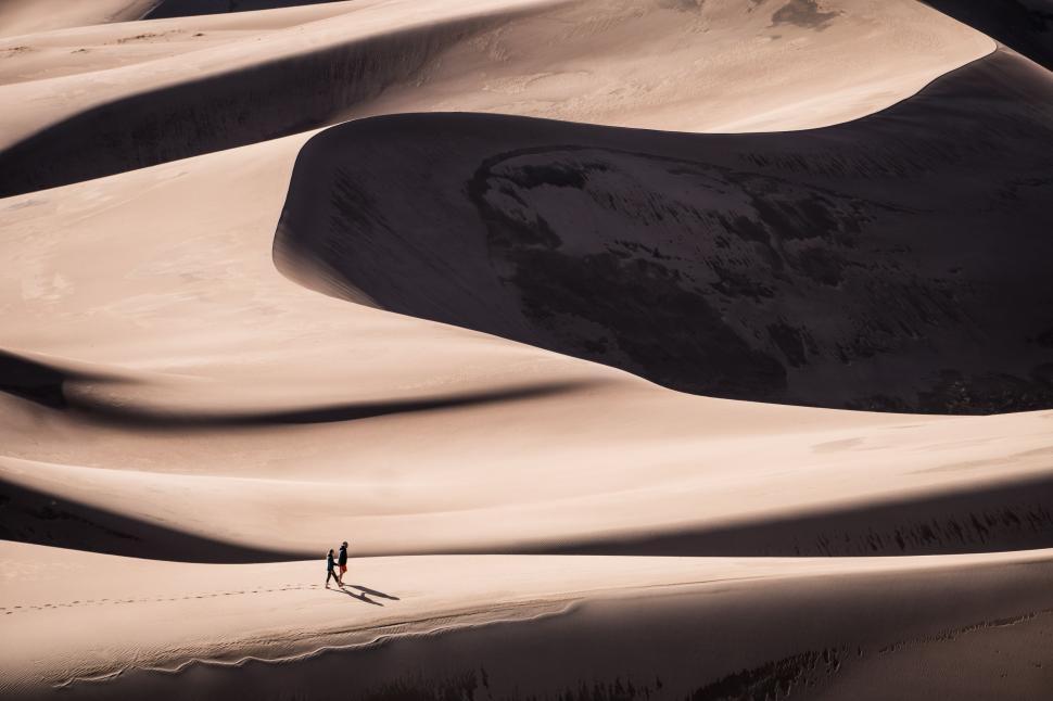 Free Image of Person Walking in the Middle of a Desert 