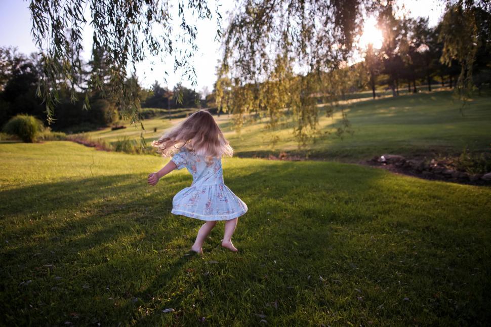 Free Image of Little Girl in Blue Dress Playing With Frisbee 