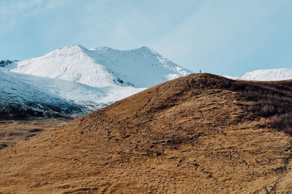 Free Image of Large Mound of Dirt With Mountain in Background 