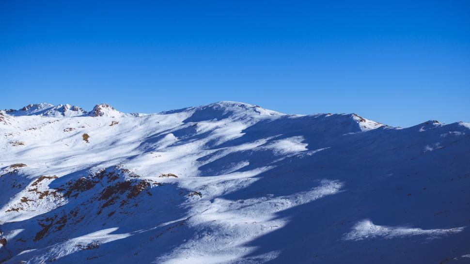 Free Image of Person Snowboarding on Snow Covered Mountain 