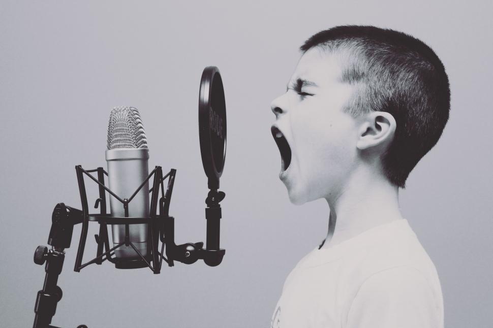 Free Image of Young Boy Singing Into Microphone 