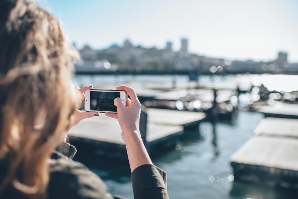 Free Image of Woman Taking Picture of Boat Dock 