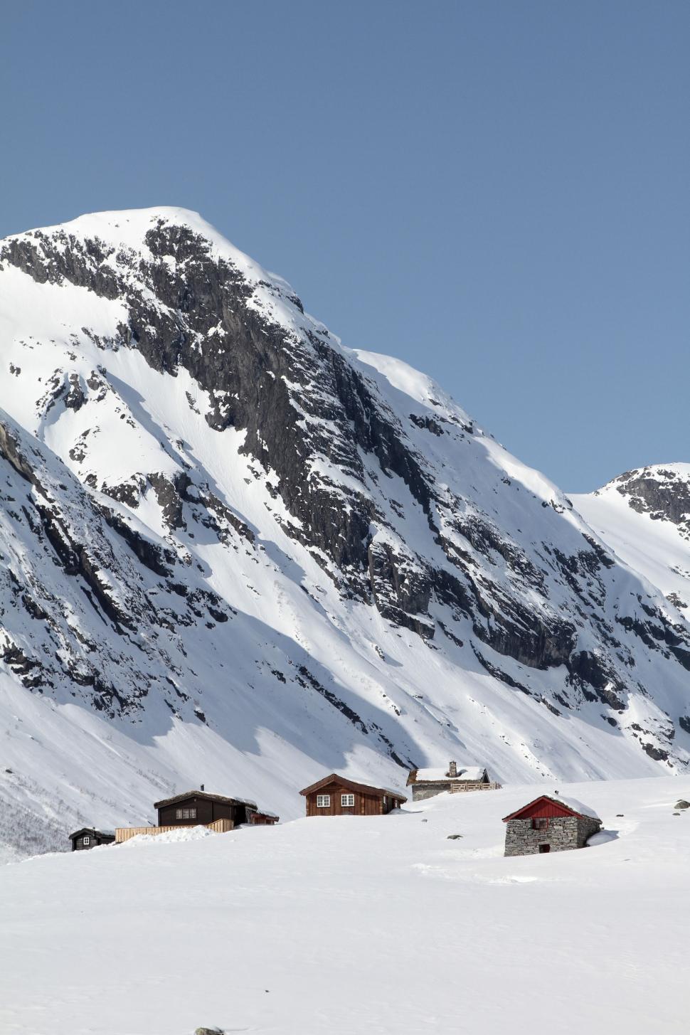 Free Image of Snow Covered Mountain With Houses in Foreground 