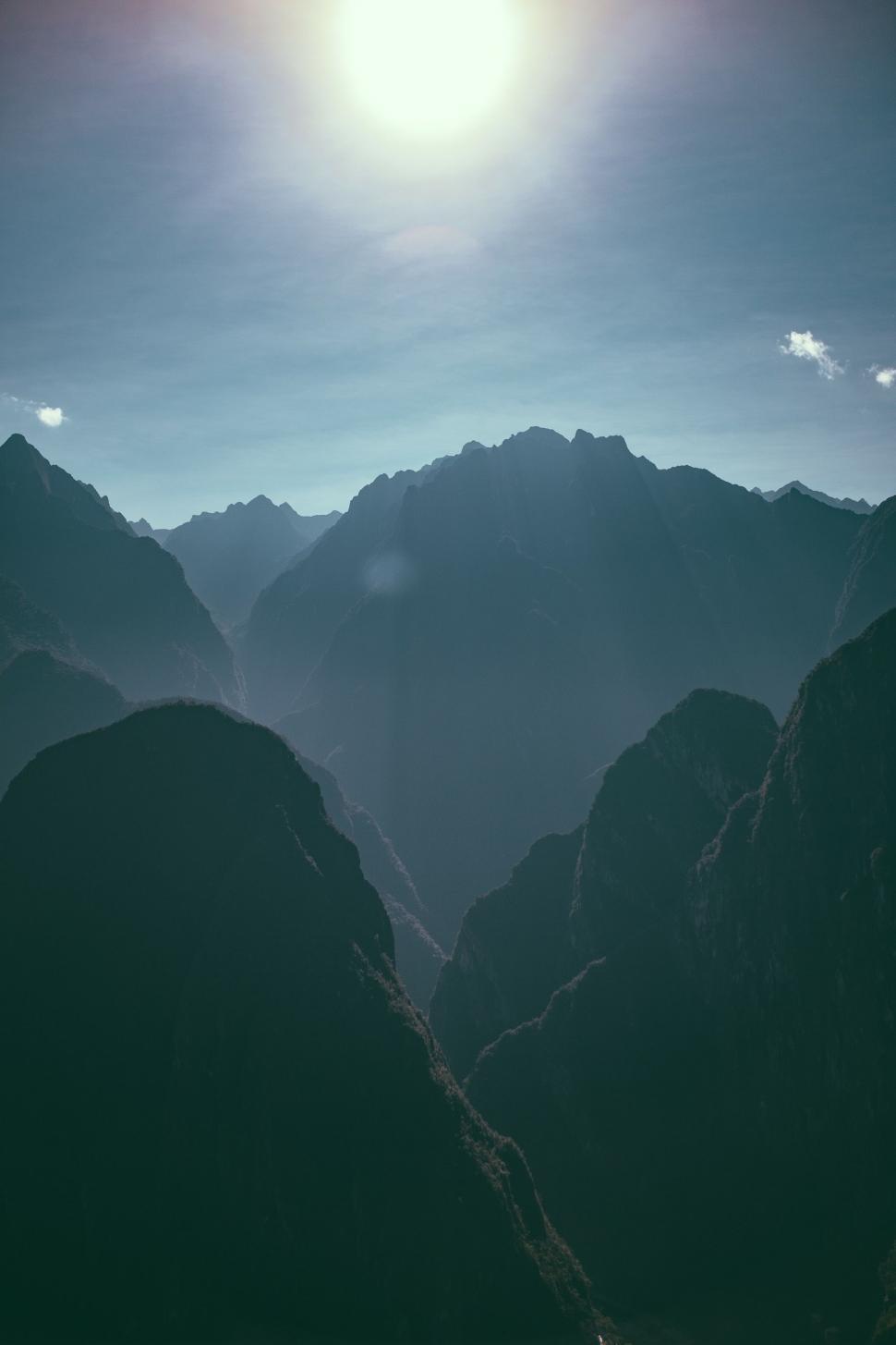 Free Image of The Sun Shines Brightly Over a Mountain Range 