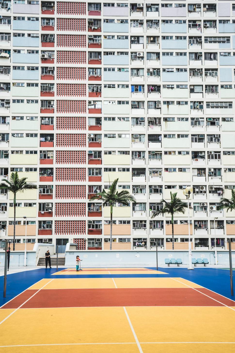 Free Image of Tennis Court in Front of Tall Building 