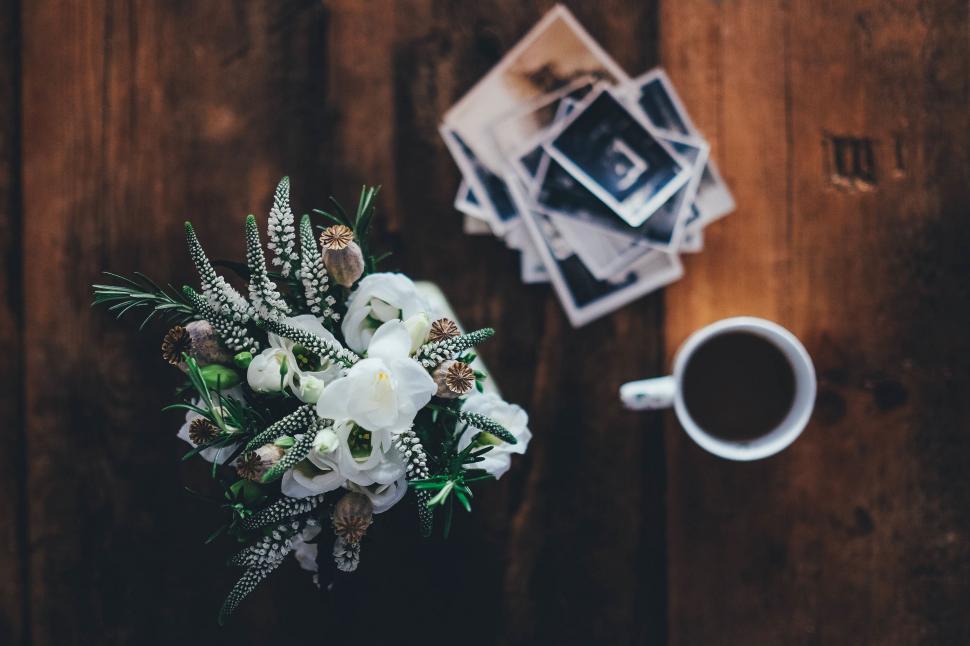 Free Image of A Bouquet of Flowers Next to a Cup of Coffee 