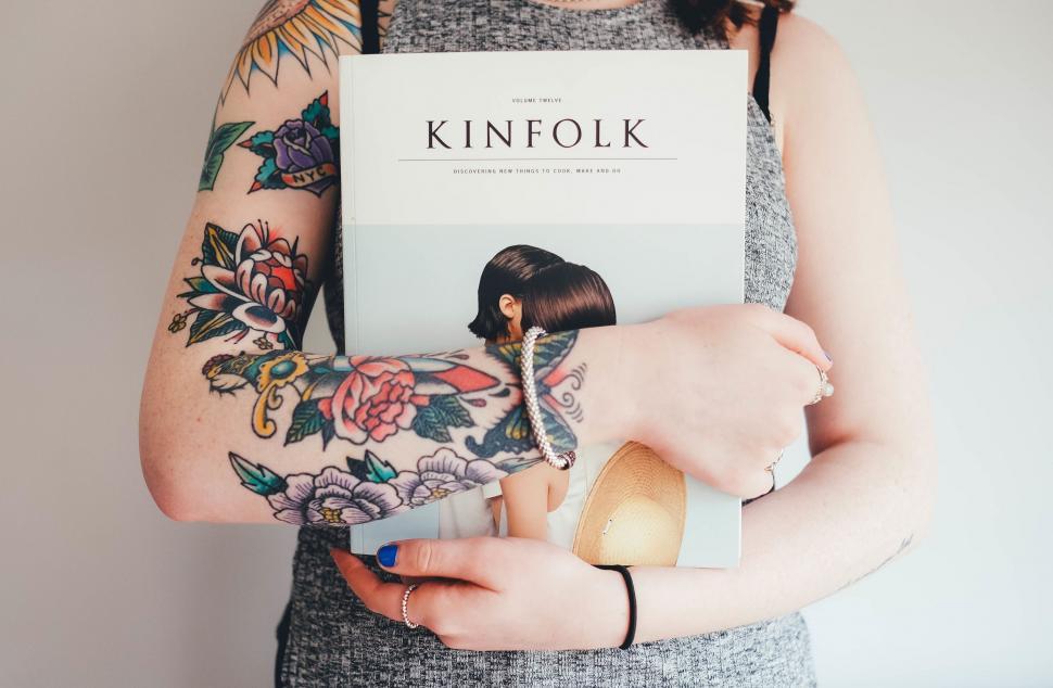 Free Image of A Woman Holding a Book in Her Hands 