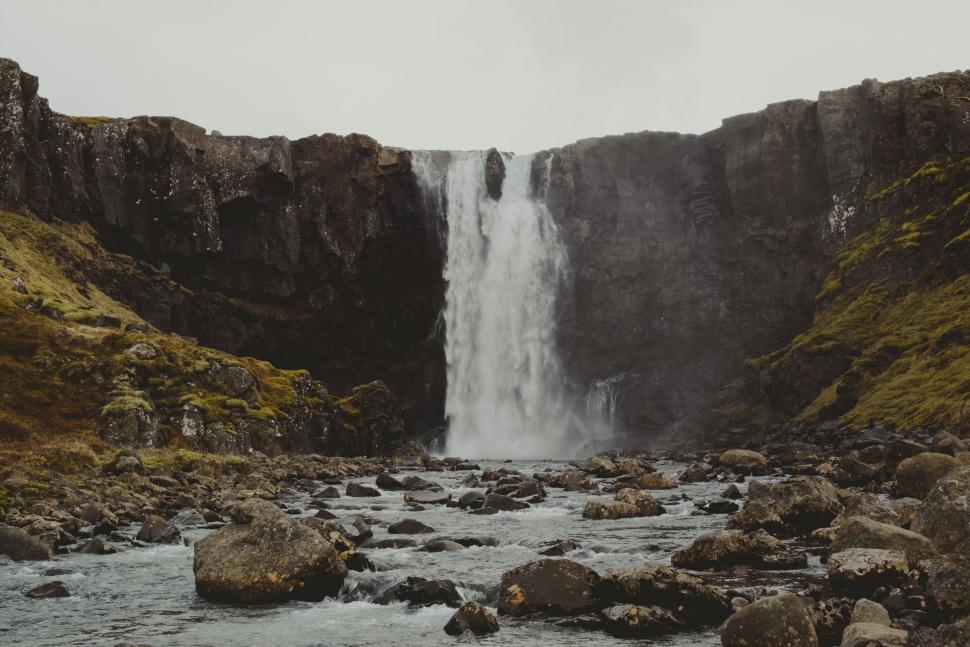 Free Image of Majestic Waterfall Surrounded by Rocky Terrain 