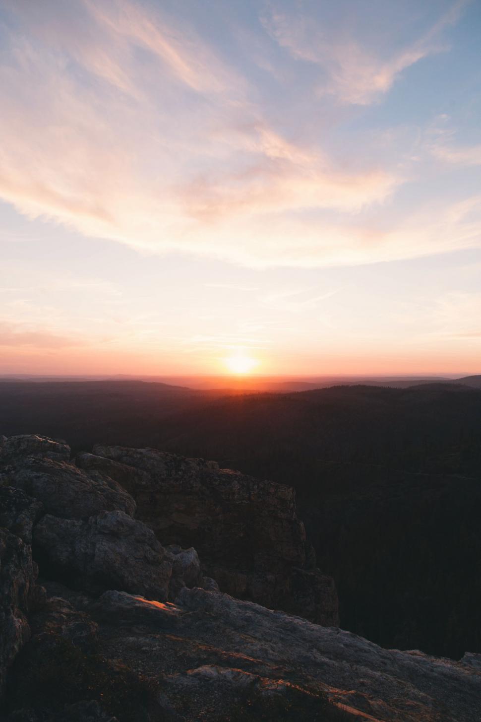 Free Image of Person Standing on Top of Cliff at Sunset 