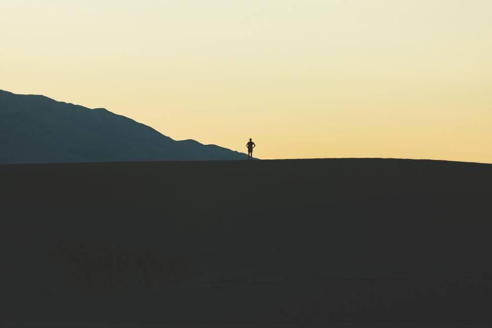 Free Image of Person Standing on Hill at Sunset 