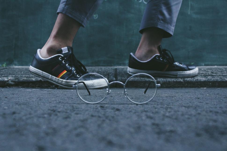 Free Image of Person Standing on Sidewalk With Glasses 