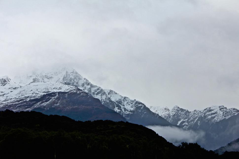 Free Image of Majestic Snow-Covered Mountain Under Cloudy Sky 