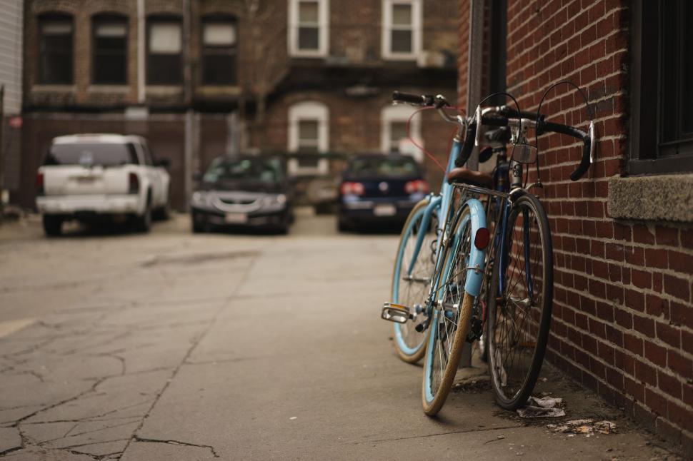 Free Image of Blue Bicycle Leaning Against Brick Wall 
