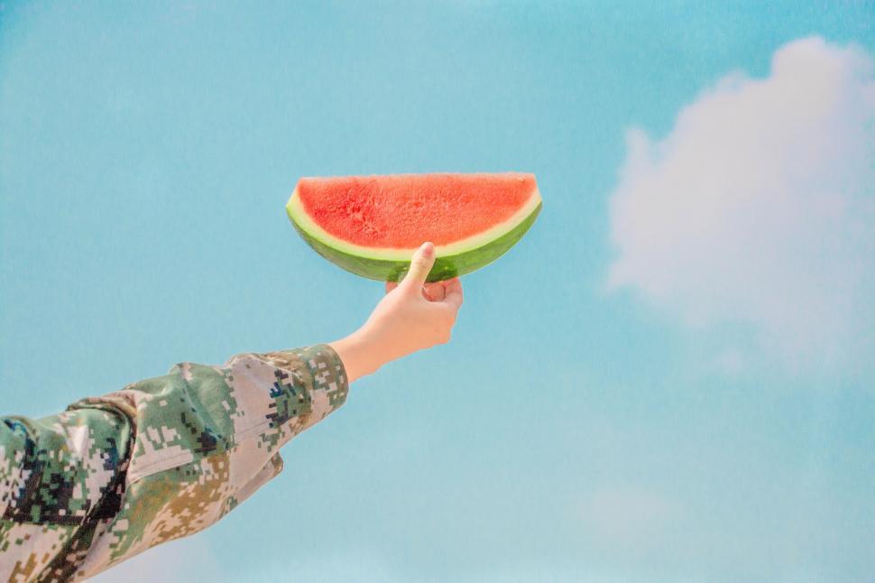 Free Image of Soldier Holding Piece of Watermelon 