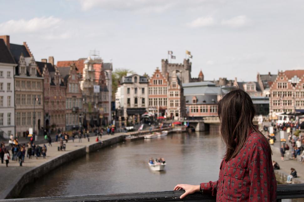Free Image of Woman Standing on Balcony, Looking at River 
