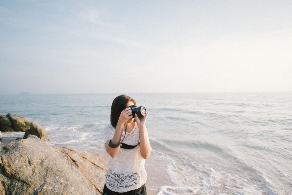 Free Image of Woman Capturing Ocean View With Camera 