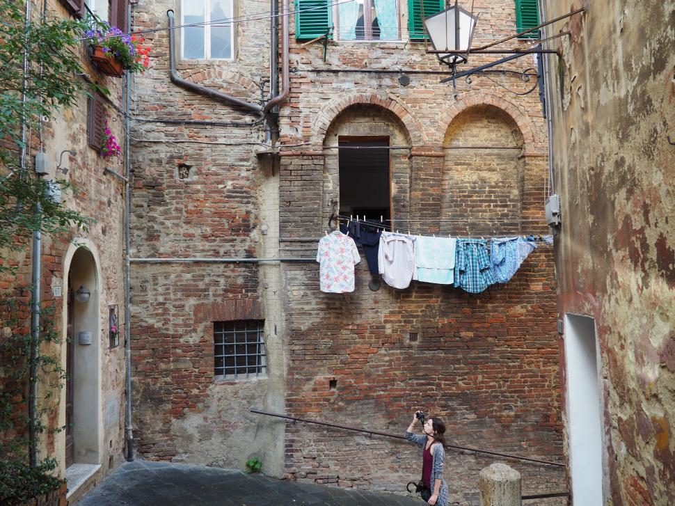 Free Image of Narrow Alleyway With Hanging Clothes 