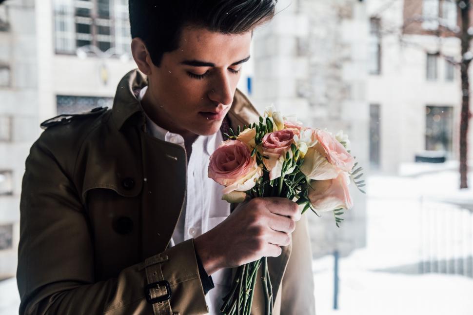 Free Image of Man in Trench Coat Holding Bunch of Flowers 