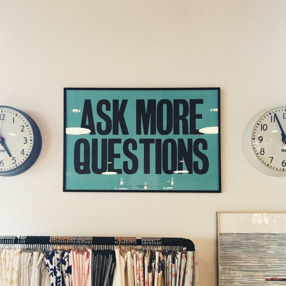 Free Image of Wall With Clocks and Sign Saying Ask More Questions 